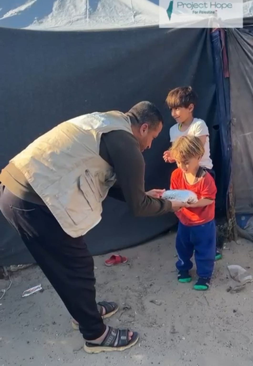 A volunteer handing a meal to a child